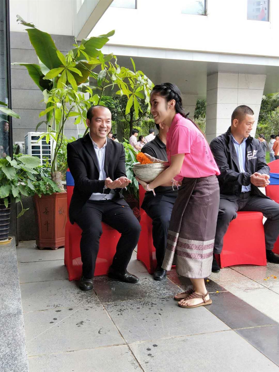 老撾駐廣西留學(xué)生代表將浸有花瓣的香水灑客人的手上，表示對(duì)嘉賓的美好祝福（圖一）