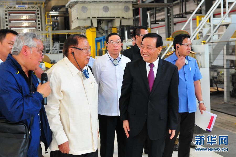 3月10日，在老撾沙灣拿吉省車邦縣，老撾人民革命黨中央總書記、國家主席本揚（左二）在山東太陽紙業(yè)股份有限公司董事長李洪信（右二）的陪同下視察公司。 新華社記者章建華攝